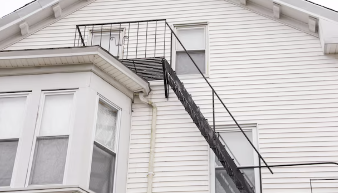 Family practicing a fire escape plan with an emergency ladder.