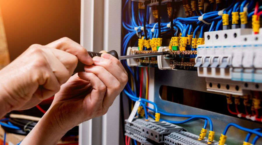 Electrician inspecting wiring in a home for fire hazards.